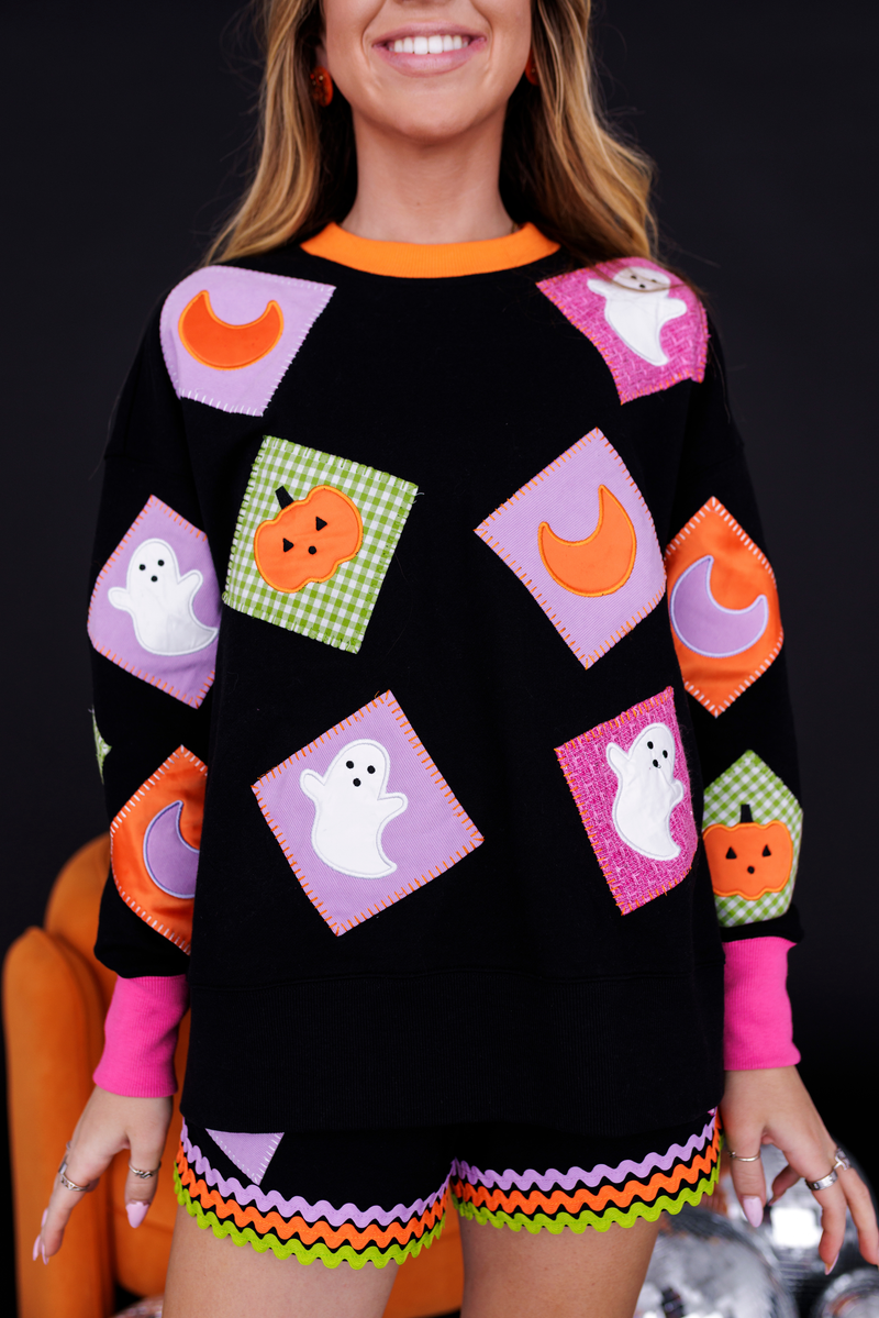 Model wearing the Patchwork Halloween Sweatshirt with ghost and pumpkin patches, front view
